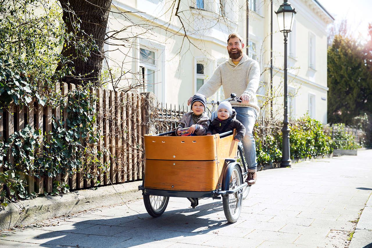 A father commuting with his children on a cargo bike